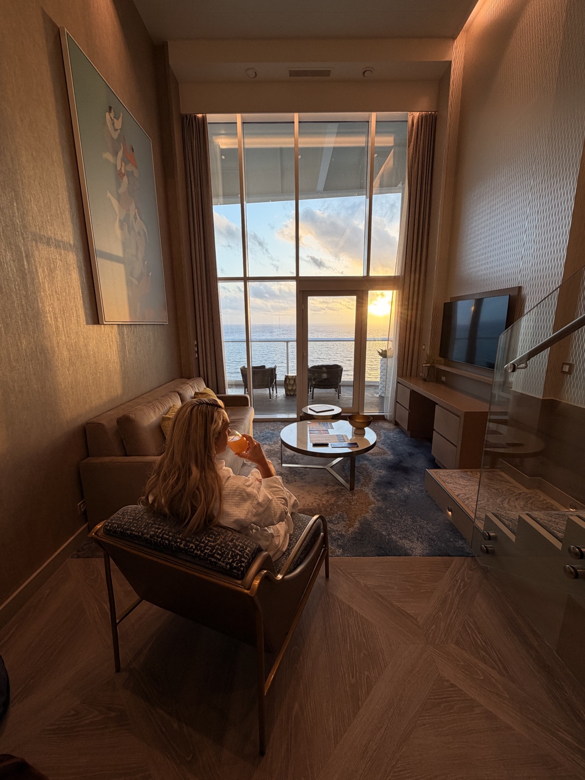 Luxury cruise suite overlooking the ocean at sunset